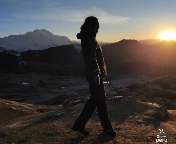 O esforço da caminhada é iluminado pela saída do sol. Observe como o dia desperta sobre os Andes. Uma experiência de paz e realização pessoal na rota matinal.